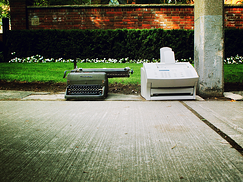 Old typewriter and fax discarded on the side of the road